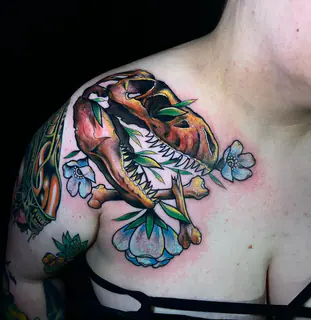 Fine-line lily tattoo on an upper arm