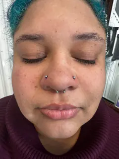 Nose and septum piercings completed by Mikey