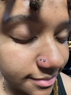 Paired nose piercings completed by Mikey