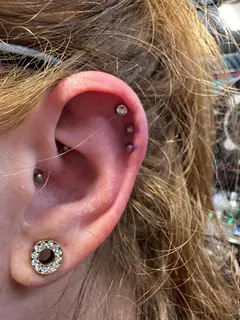Curated cartilage ear piercings completed by Mikey